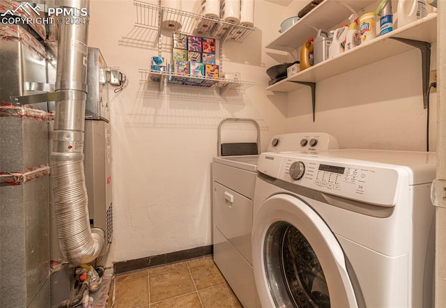 washroom with independent washer and dryer, light tile patterned floors, and heating unit