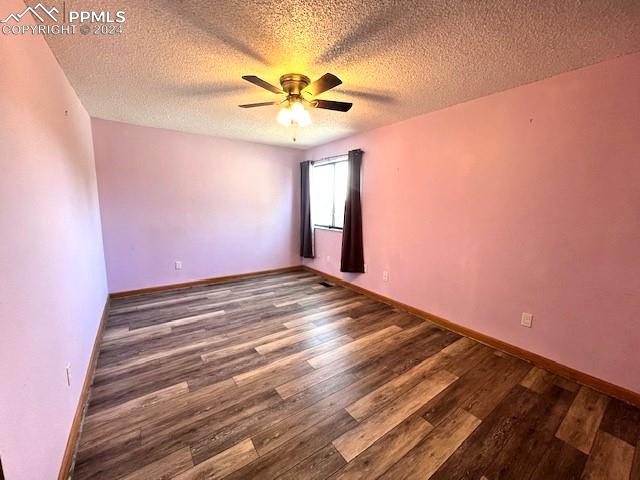 spare room with a textured ceiling, ceiling fan, and hardwood / wood-style floors