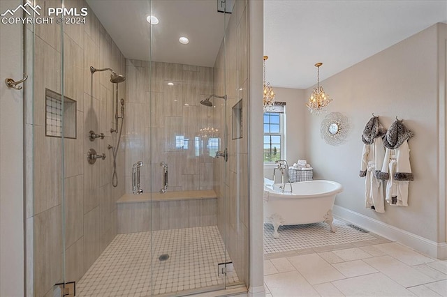 bathroom with tile floors, an inviting chandelier, and separate shower and tub