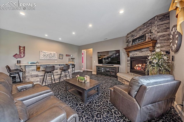 carpeted living room with a stone fireplace and indoor bar