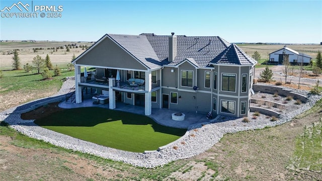 rear view of house featuring a balcony and a patio