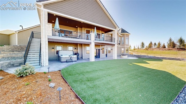 rear view of property with a patio, a balcony, and a yard