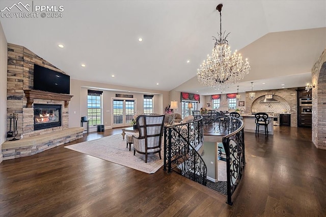 living room featuring a notable chandelier, vaulted ceiling, and dark hardwood / wood-style flooring