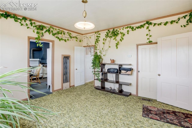 carpeted dining space with crown molding