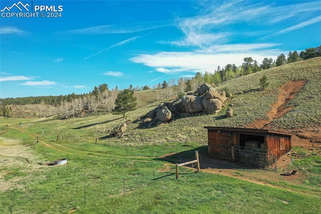 view of yard with an outdoor structure and a rural view