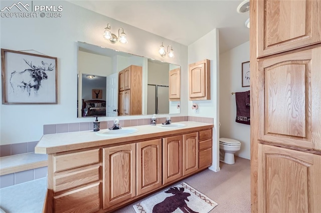 bathroom featuring toilet, double sink, and oversized vanity