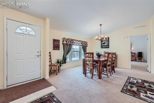 carpeted dining area featuring vaulted ceiling and an inviting chandelier