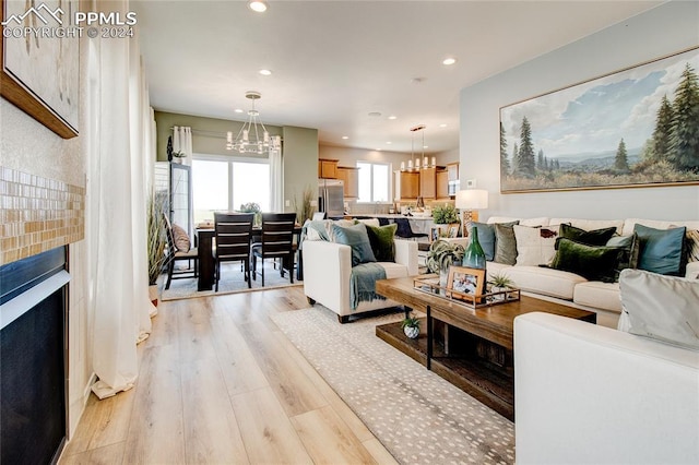 living room with light hardwood / wood-style floors and a notable chandelier