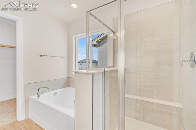 9759 Feathergrass Dr, Colorado Springs, CO 80927 - bathroom featuring a stall shower, a bath, a walk in closet, and recessed lighting