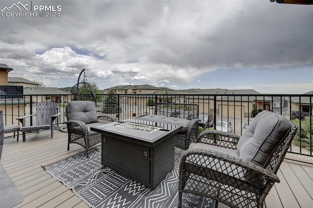 wooden deck featuring an outdoor living space with a fire pit