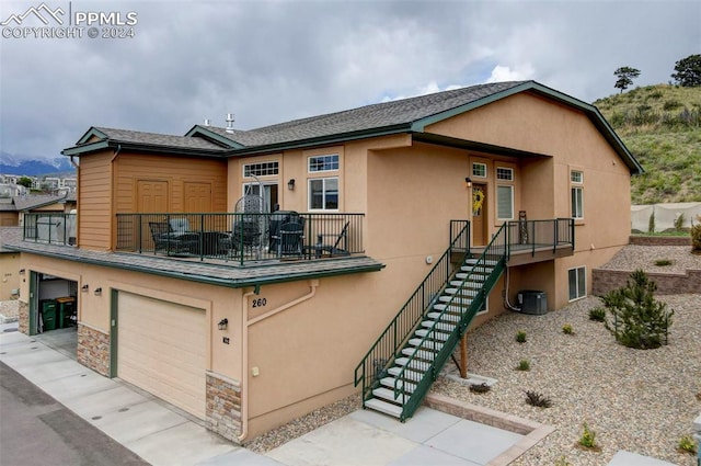 exterior space with central air condition unit and a garage