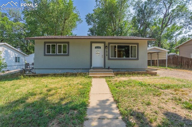 view of front of house with a carport and a front lawn