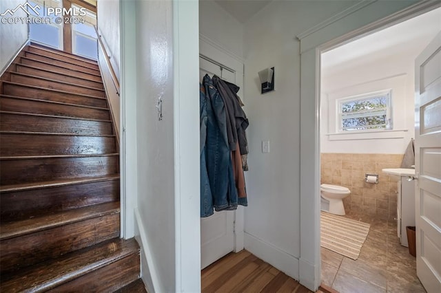 stairs featuring tile walls