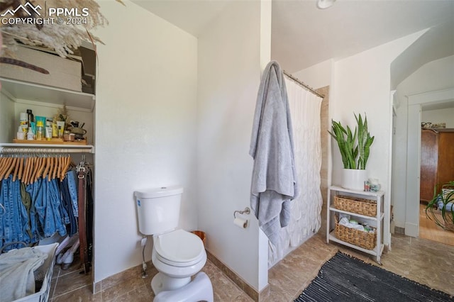 bathroom with toilet and curtained shower