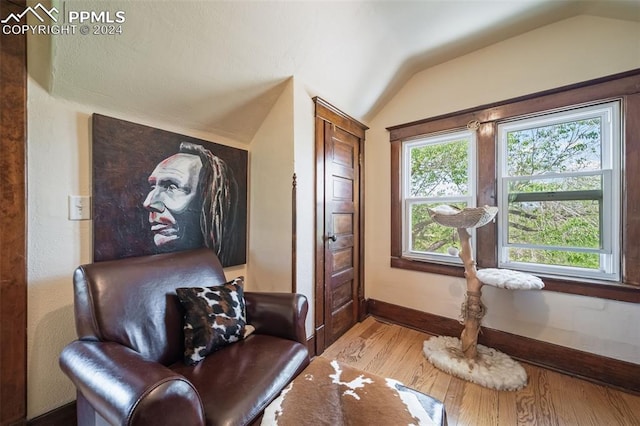 living area with hardwood / wood-style floors and vaulted ceiling