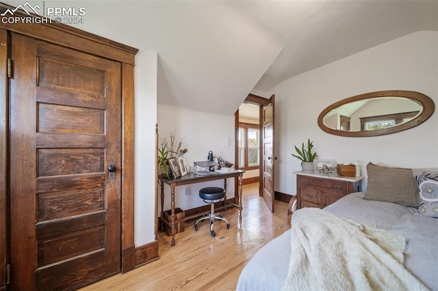 bedroom with vaulted ceiling and light wood-type flooring