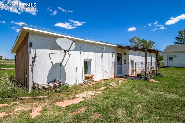 rear view of property with a yard