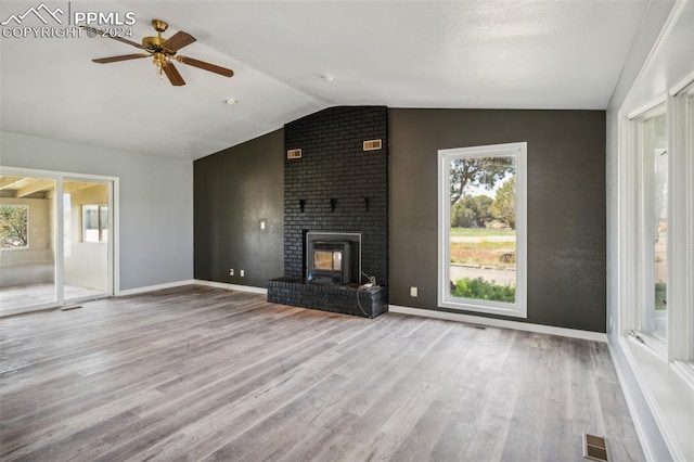 unfurnished living room with ceiling fan, lofted ceiling, a fireplace, and light hardwood / wood-style flooring