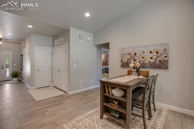 dining area with ceiling fan, light hardwood / wood-style flooring, and high vaulted ceiling