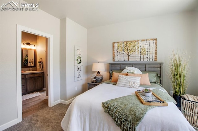 carpeted bedroom featuring ensuite bathroom and sink