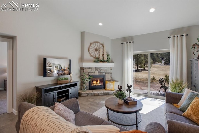 living room featuring a stone fireplace and light hardwood / wood-style floors