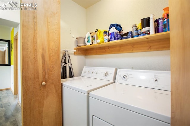 laundry area with hardwood / wood-style flooring and washing machine and dryer