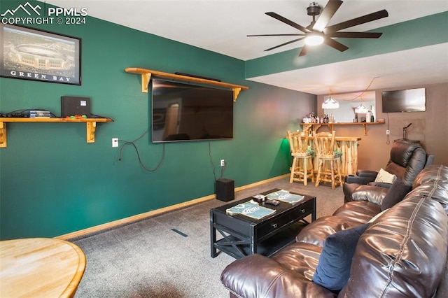 living room with ceiling fan, bar, and carpet