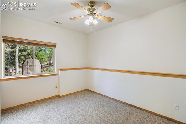 carpeted spare room with ceiling fan