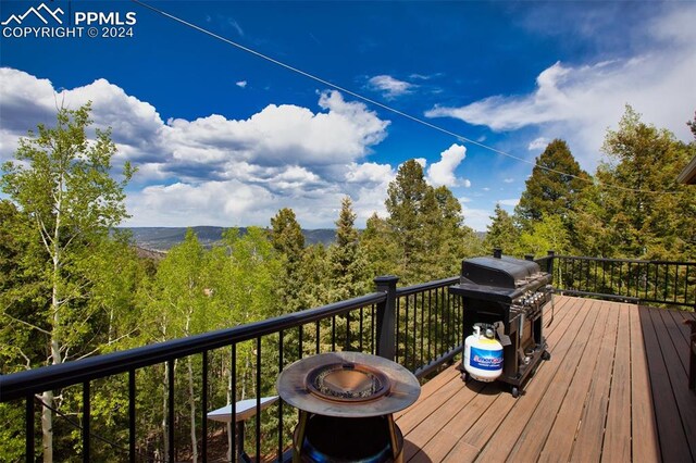 wooden terrace with a grill and a fire pit