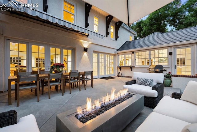 view of patio with an outdoor living space with a fire pit