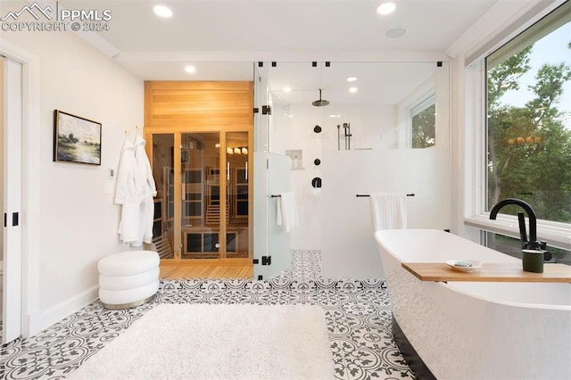 bathroom featuring tile patterned flooring, independent shower and bath, and a wealth of natural light