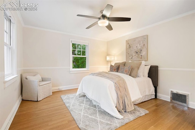 bedroom featuring hardwood / wood-style flooring, ceiling fan, and ornamental molding