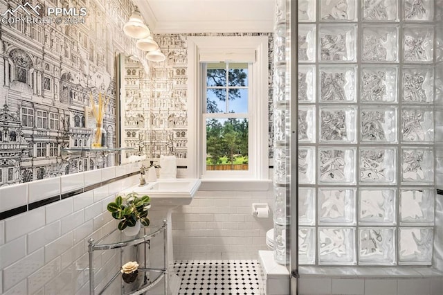 bathroom featuring toilet, tile walls, crown molding, and sink