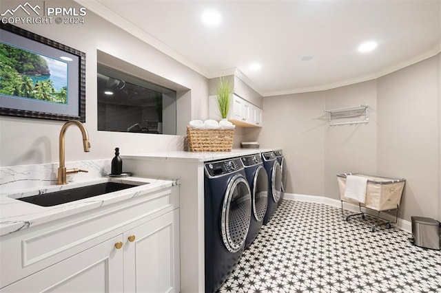 laundry area featuring crown molding, washing machine and dryer, and sink