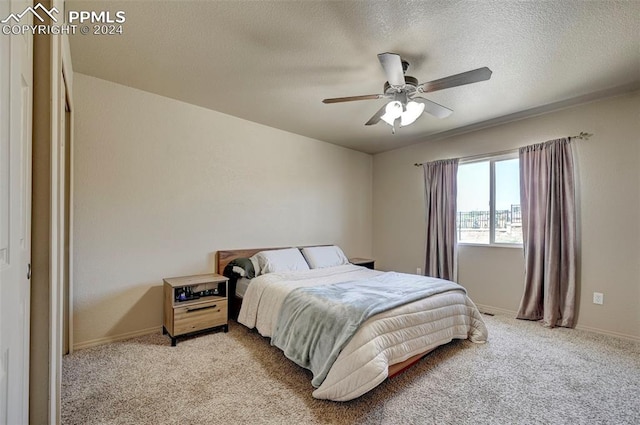 bedroom with a textured ceiling, ceiling fan, and carpet floors