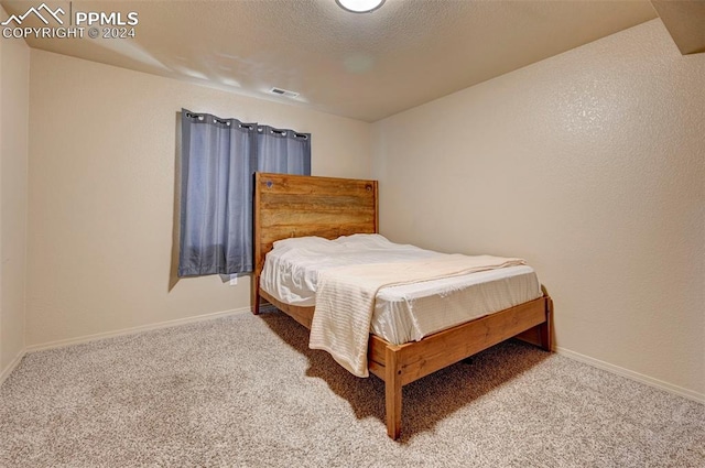 bedroom with carpet and a textured ceiling