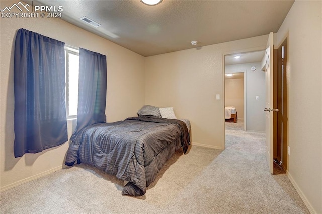 bedroom featuring carpet flooring and a textured ceiling