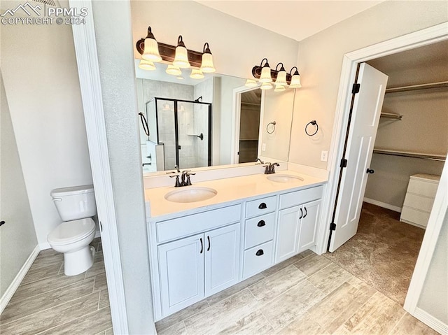 bathroom featuring double vanity, walk in shower, tile patterned floors, and toilet