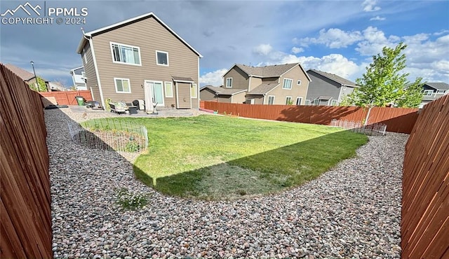 rear view of house with a yard and a patio area