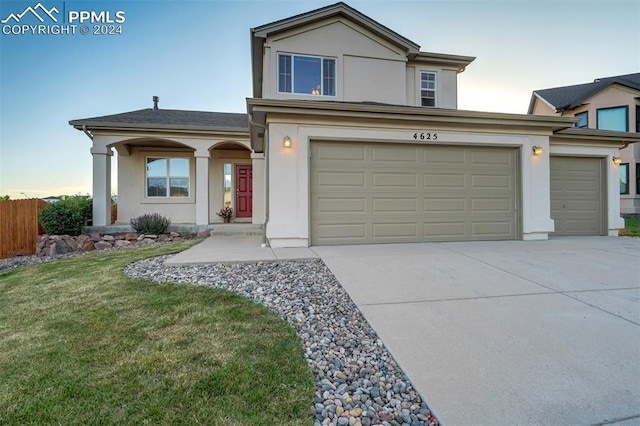 view of front facade featuring a garage and a yard