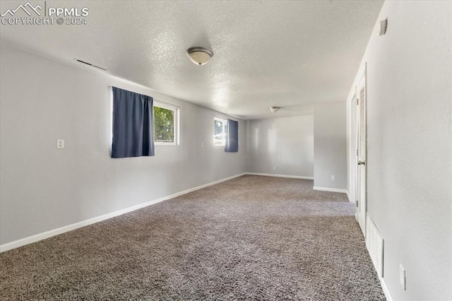 empty room featuring carpet flooring and a textured ceiling