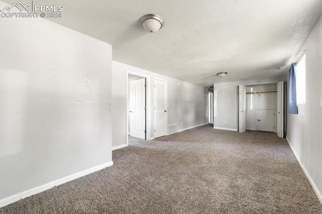 empty room featuring carpet floors and a textured ceiling