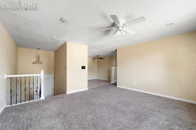 spare room featuring ceiling fan, carpet floors, and a textured ceiling