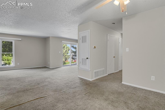 carpeted spare room with a textured ceiling and ceiling fan