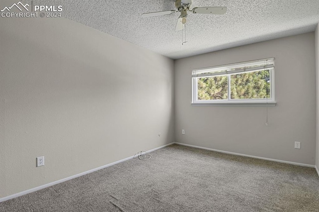 carpeted empty room featuring ceiling fan and a textured ceiling