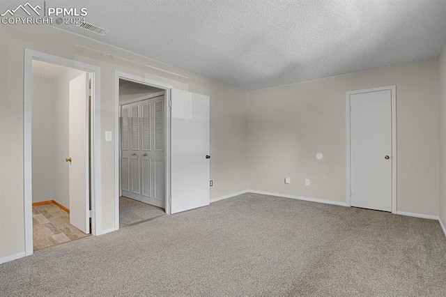 carpeted spare room with a textured ceiling