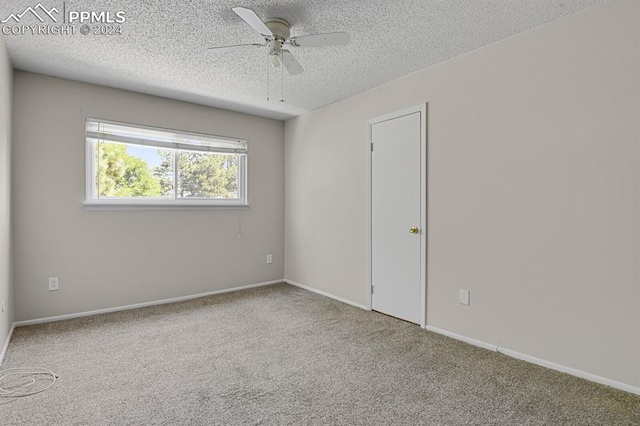 spare room featuring ceiling fan, light carpet, and a textured ceiling