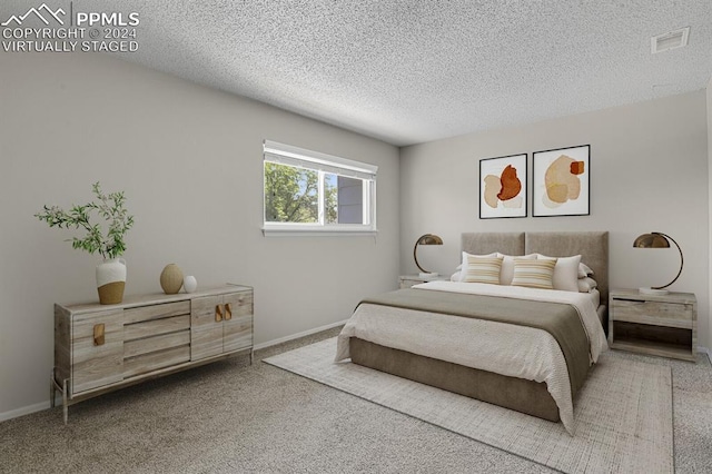 bedroom with a textured ceiling and carpet flooring