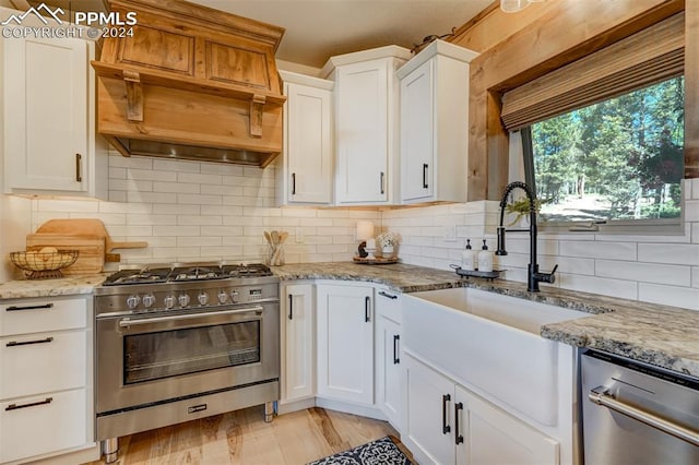 kitchen with backsplash, appliances with stainless steel finishes, and light stone countertops