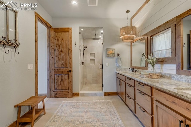 bathroom with dual vanity, tile flooring, and a shower with shower door